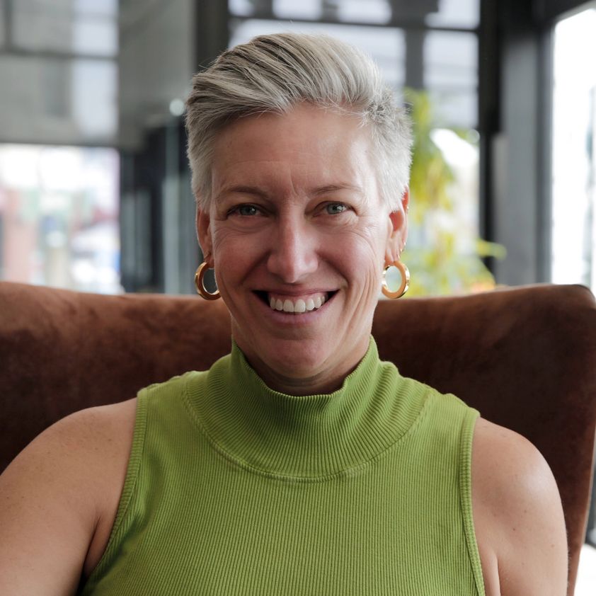 Lindsay LaShell, smiling, seated in a leather chair. Photo by Myra Thomas, Denver, 2025.